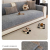 Helles graues Sofa mit strukturiertem Stoff und dekorativen Kissen auf einem beige Teppich.