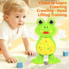 A baby is interacting with a green frog toy designed for head lifting crawling training.
