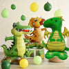 A collection of green and yellow dinosaur foil balloons hanging in the air.