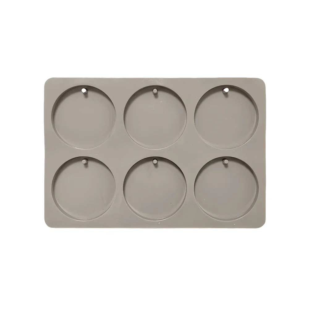 A gray silicone mold with six circular cavities for making soap or aromatherapy discs.