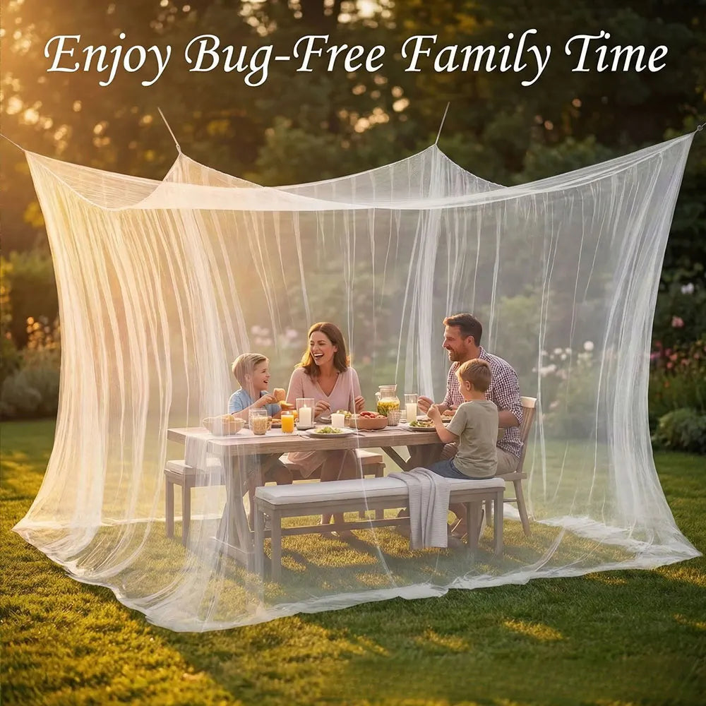 A family enjoying time under a large sheer white mesh fly net canopy on a grassy lawn.