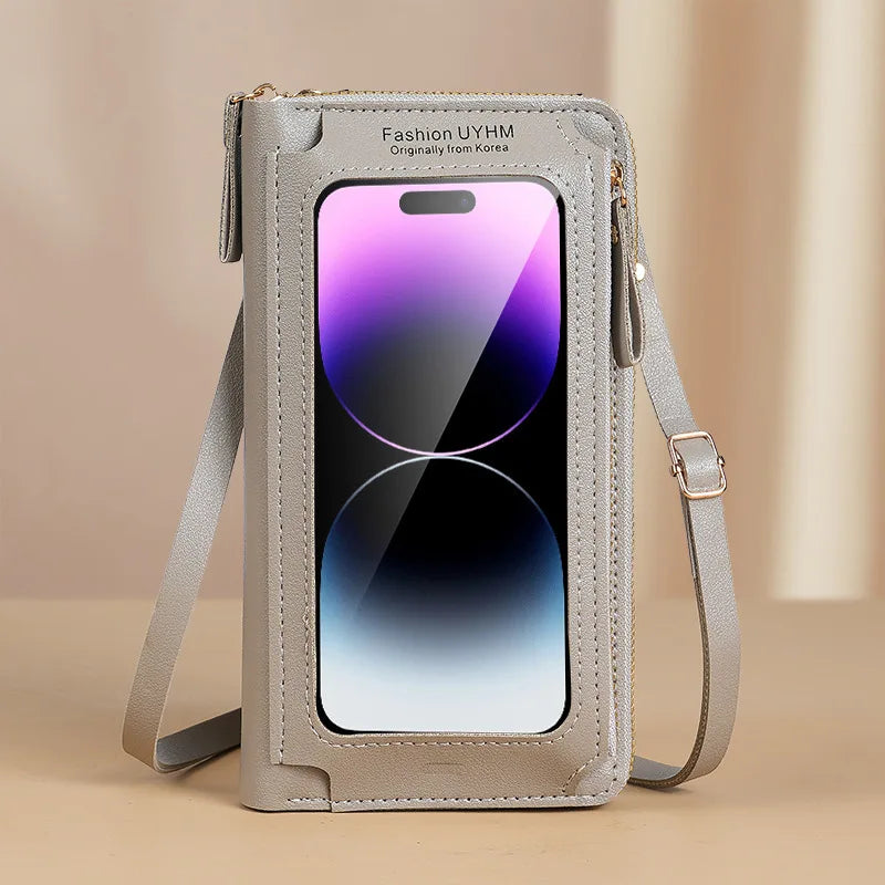 A light gray hands-free crossbody phone bag with a clear window displaying a smartphone.