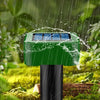 A green solar-powered ultrasonic animal repellent device is shown outdoors in a garden setting with rain falling.