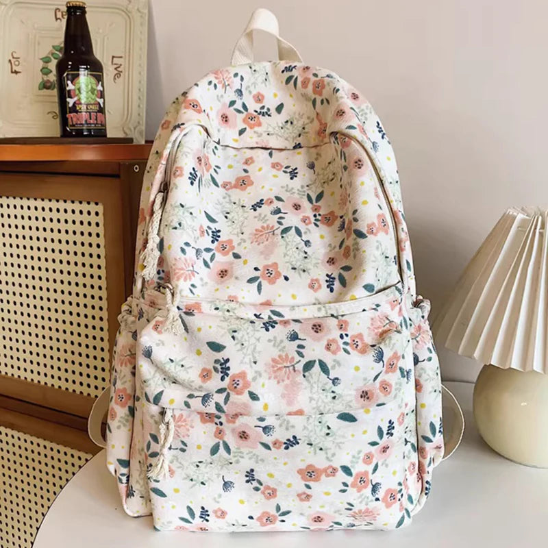 A floral patterned backpack set featuring a main bag, a handbag, and a pencil case.