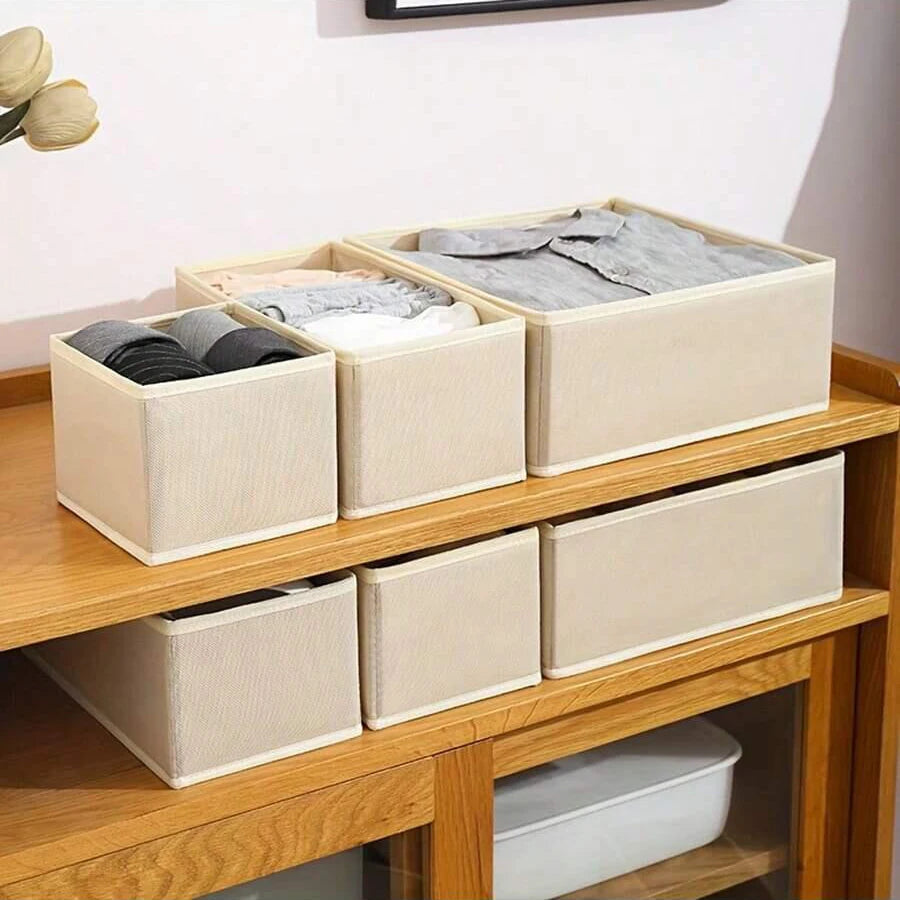 Wooden drawer organizer boxes used to store folded underwear, bras, and socks.
