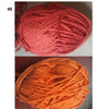 A close-up of a skein of soft orange yarn used for knitting and crochet projects.