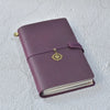 A purple handcrafted leather refillable journal with a gold-toned tassel detail.