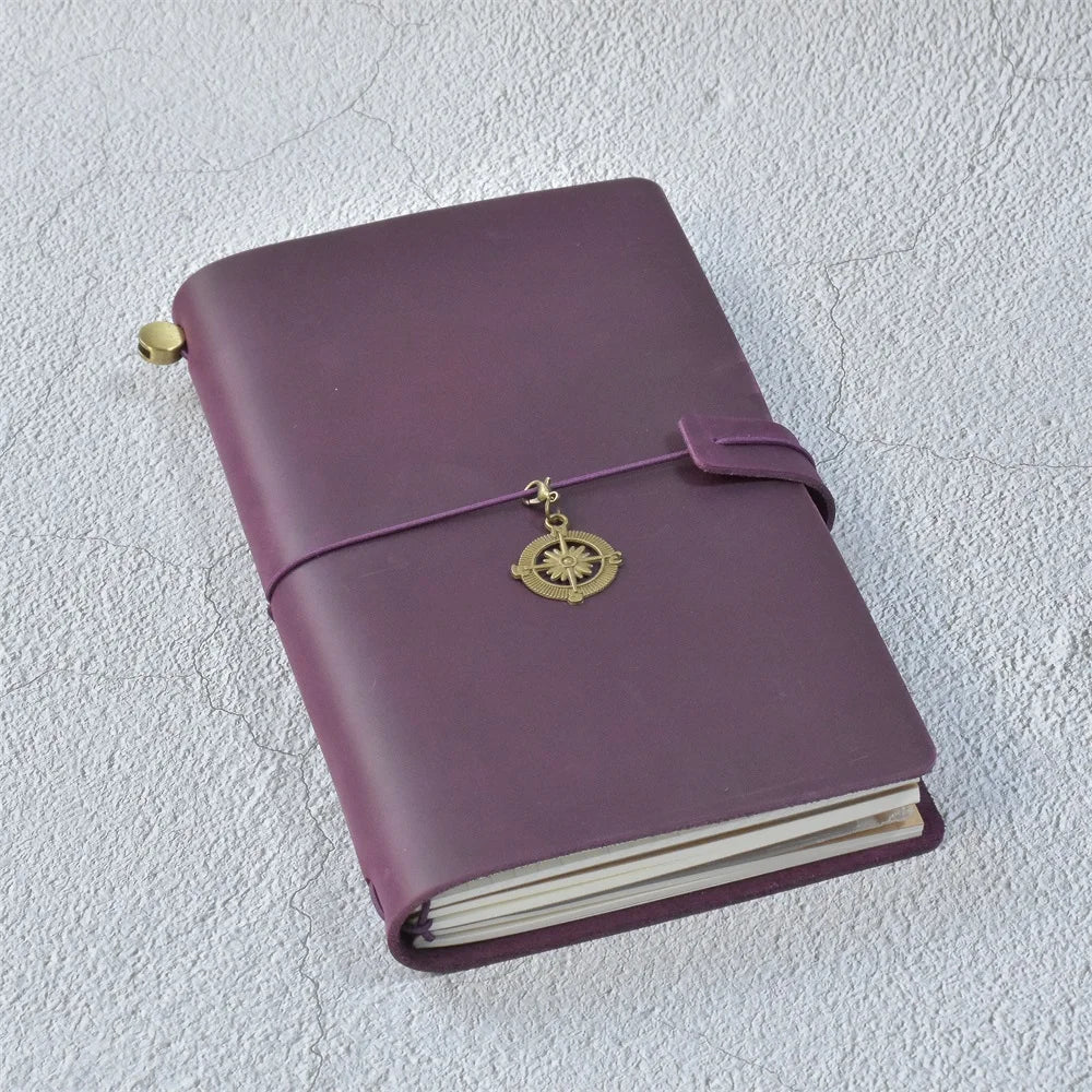 A purple handcrafted leather refillable journal with a gold-toned tassel detail.