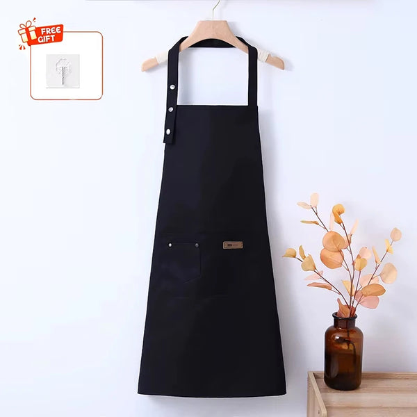 Black stain-resistant kitchen apron hanging on a wooden hanger against a white wall.