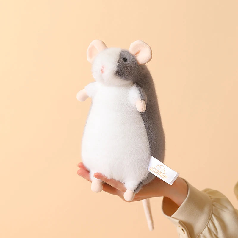 A white and gray plush mouse stuffed animal being held in a person's hand.
