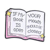 Enamel pin featuring an open book design with text If my book is open your mouth should be closed