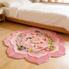 A round plush rug featuring a pink background with colorful koi fish patterns on a light wooden floor.