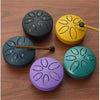 A collection of six mini steel tongue drums in various colors, including black, yellow, purple, and green, with wooden mallet