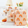 A pair of light pink and beige mini waterproof wet dry bags with rainbow patterns are displayed on a white surface.