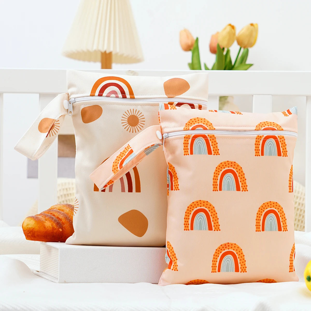 A pair of light pink and beige mini waterproof wet dry bags with rainbow patterns are displayed on a white surface.