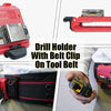 A red clip-on drill holder with a belt clip mounted on a tool belt, shown being held by a hand.