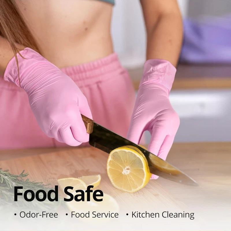 Pink nitrile disposable gloves are shown handling a lemon on a wooden cutting board for food service and kitchen cleaning.