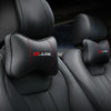 Black leather car seat with red stitched neck pillows and headrests.
