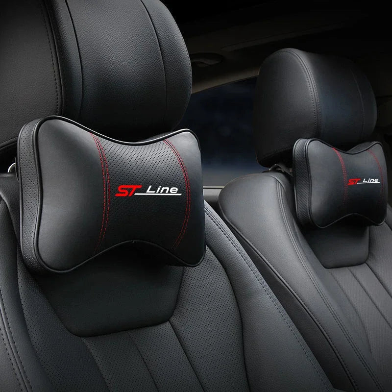 Black leather car seat with red stitched neck pillows and headrests.
