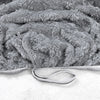 Gros plan d'une housse de canapé jacquard grise et duveteuse avec détail zippé.