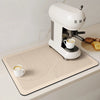 A white espresso machine is placed on a beige quick-dry diatom mud absorbent counter mat.