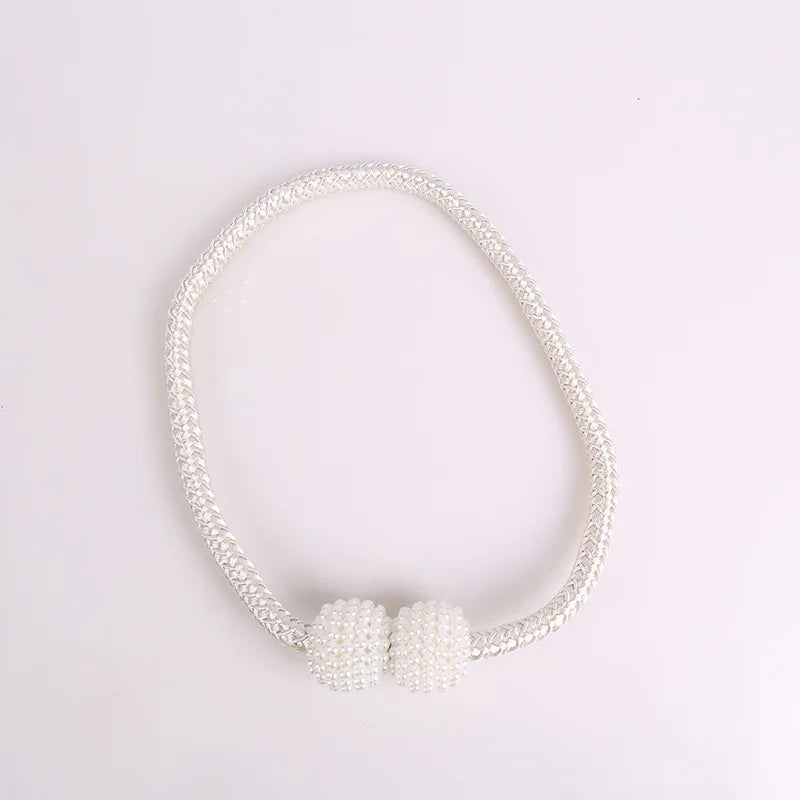 A set of eight elegant pearl magnetic curtain tie-back clips forming a delicate bracelet.