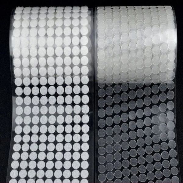 Roll of self-adhesive hook and loop dot fasteners in white