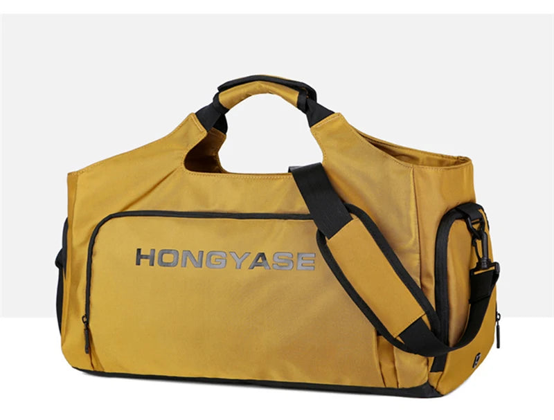 A tan duffel bag with a black strap and a shoe pocket visible against a light background.