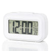 A white compact LED digital alarm clock with a display showing 12:00 and temperature settings.
