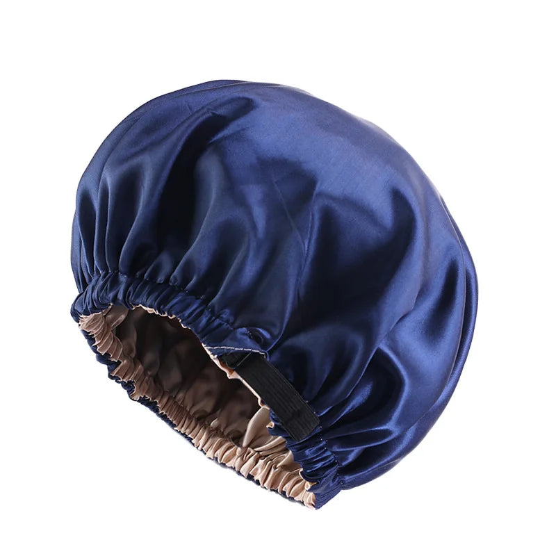 A navy blue satin sleep bonnet with a gathered edge is shown from above.