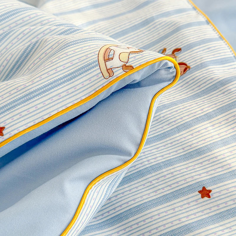 Light blue striped quilt with a cartoon animal print and a star detail.
