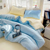 A light blue cotton bedding set featuring a duvet cover, flat sheet, and pillows in various shades of blue and cream.