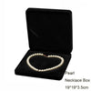 Black velvet necklace box containing a strand of white pearls