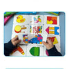 A pair of hands holds a wooden puzzle card game featuring various animal and fruit shapes.