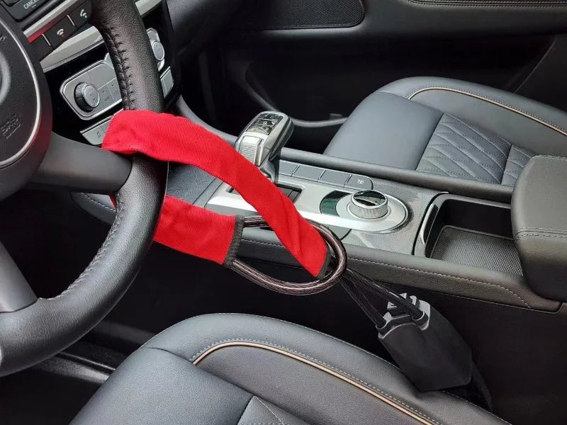 Verrou universel rouge de volant avec ancre de ceinture dans l'habitacle d'une voiture.