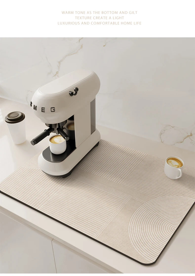 A white and gray coffee grinder sits on a beige counter mat in a bright kitchen setting.