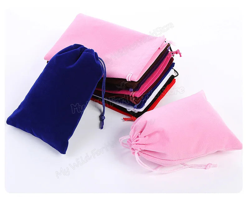A stack of pink and purple drawstring storage bags next to a dark blue bag.