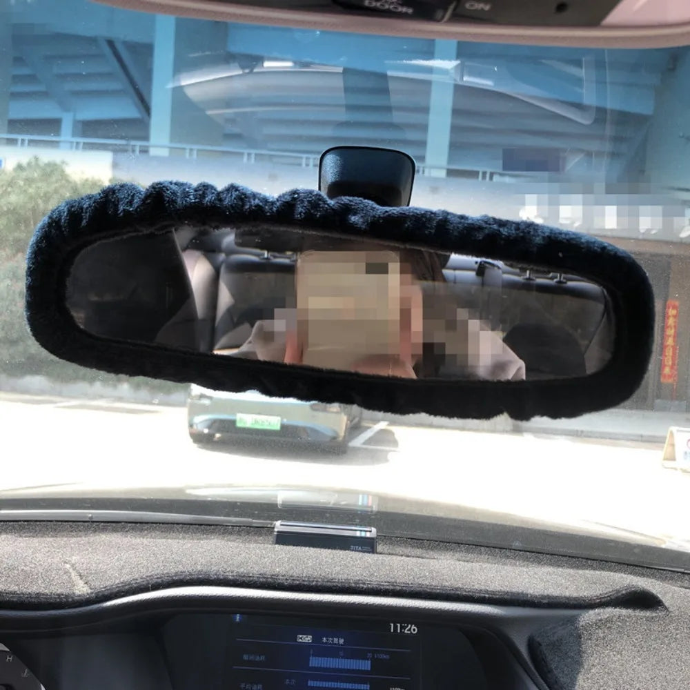 Rearview mirror covers with black fluffy trim installed on a vehicle interior.