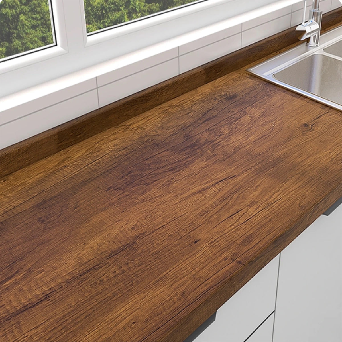 A close-up view of a dark brown wood grain countertop with a stainless steel sink and white cabinetry.