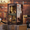 A wooden book nook kit featuring a detailed scene of a detective agency and a house, displayed on an old book.