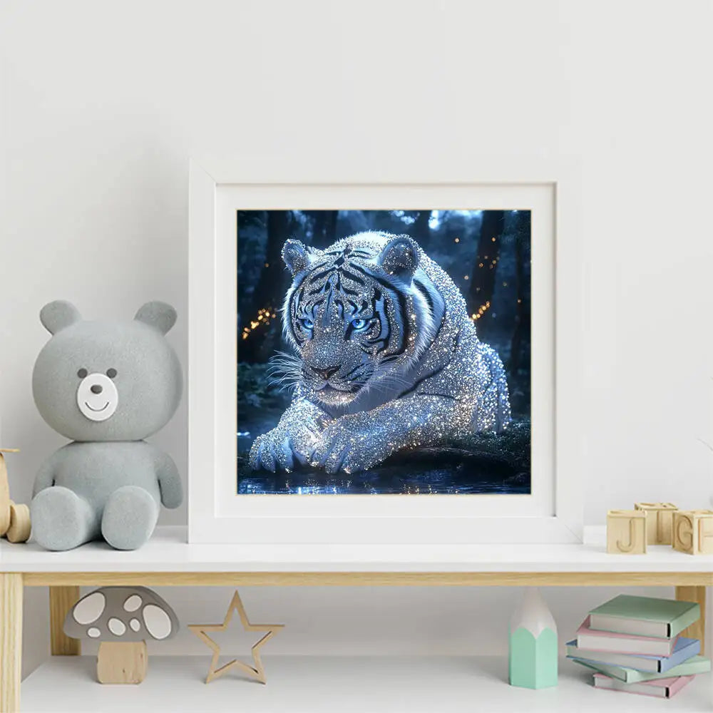 A framed print of a majestic tiger covered in sparkling blue and silver glitter, displayed next to a soft gray stuffed bear.