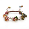 A bracelet made of braided natural crystal chips and stones with a brown macrame cord.