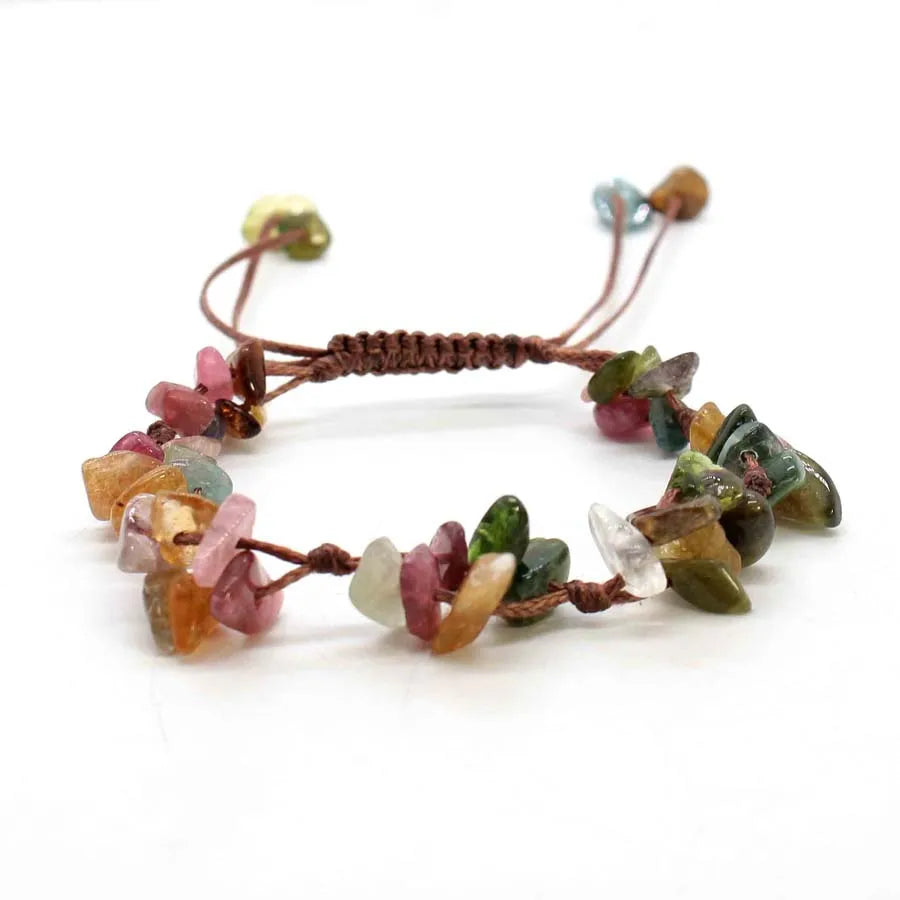 A bracelet made of braided natural crystal chips and stones with a brown macrame cord.