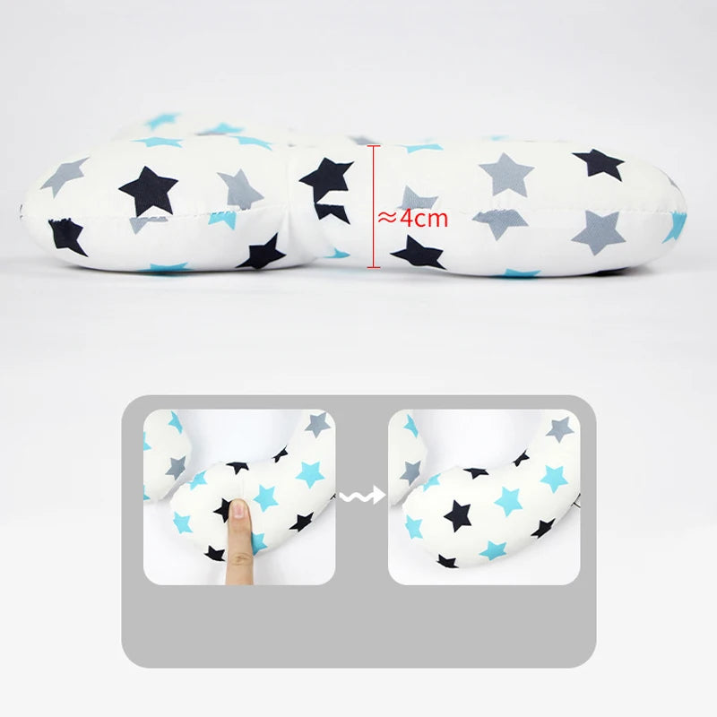 A white baby head and neck support pillow featuring black and light blue stars, shown with a measurement guide.