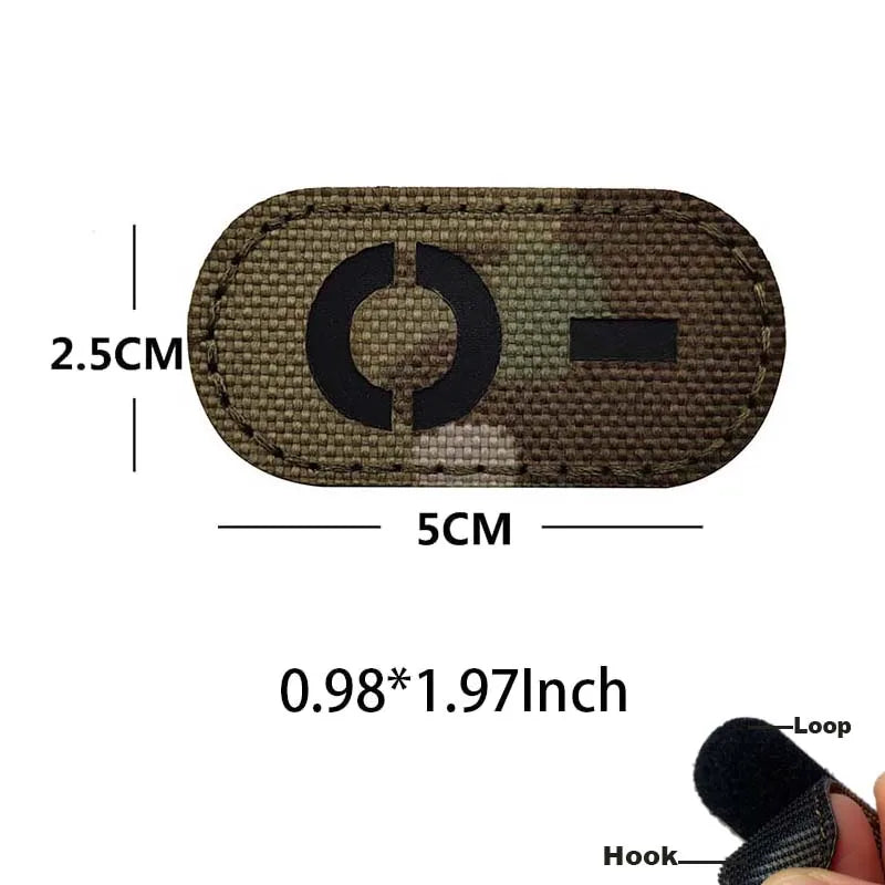 A rectangular tactical patch with a circular design and hook and loop backing, measuring 2.5cm by 5cm.