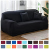 A black elastic stretch sofa cover for a 1-4 seater or L-shaped couch displayed indoors.