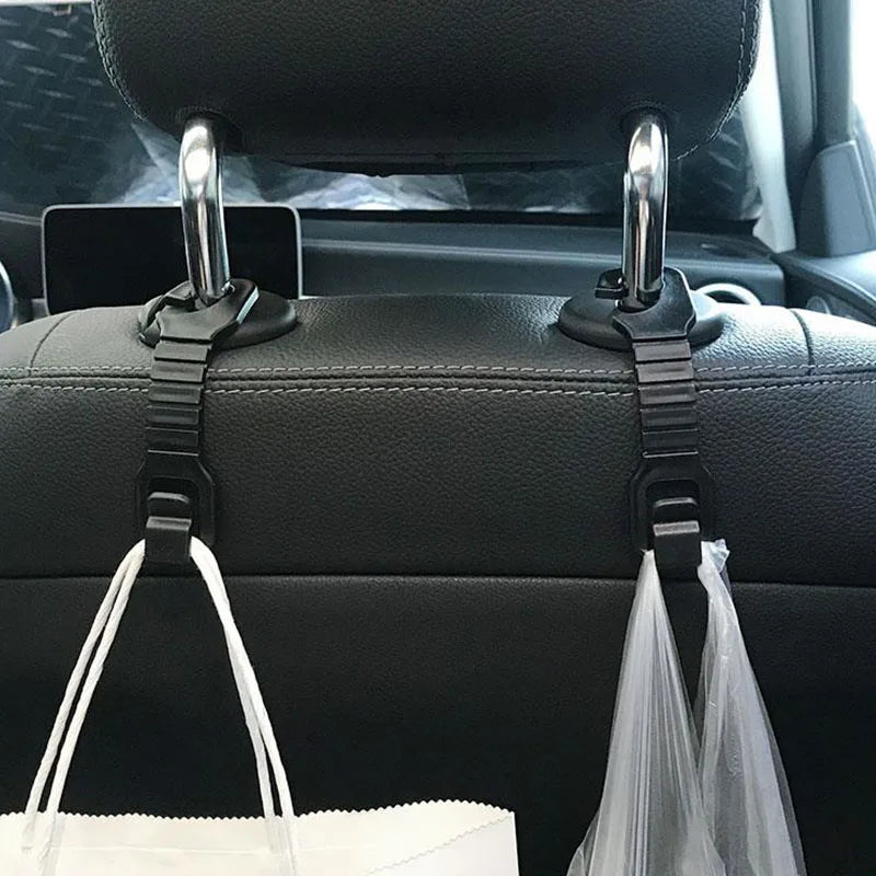A pair of universal car headrest hooks with storage hangers are shown in a black car interior.