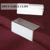A set of 10 clear table clips and a silver ice silk table skirt are displayed on a dark red fabric.