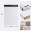 A set of five white self-sealing mailing bags and various knitted gloves are displayed.