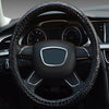 Close-up view of a black crocodile grain leather car steering wheel cover inside a vehicle